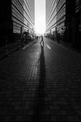 Silhouette of pedestrian under sunset in downtown district