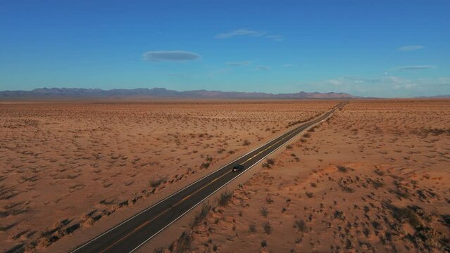 Car driving in the desert on a road from California to Arizona. Cinematic landscape.