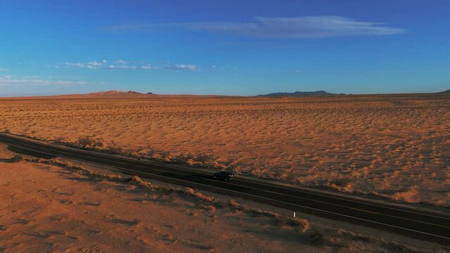 Modern car driving in the desert on a street from California to Arizona. Cinematic landscape.
