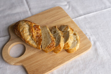 Rustic charm captured in sliced French bread on a wooden board. A simple yet inviting scene, showcasing the artistry of fresh, crusty baguette slices.