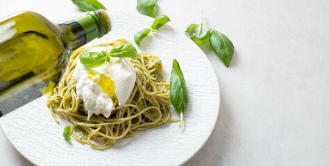 Basil pasta with burrata cheese on a plate	