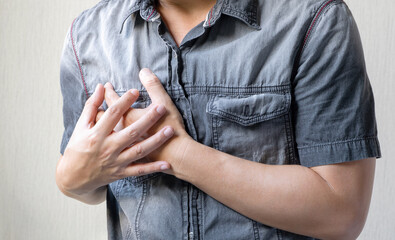 Man is sick and in pain and uses his hands to squeeze his chest He had chest pain caused by an...