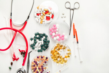 Differents pills and stethoscope on white background. Medicine concept