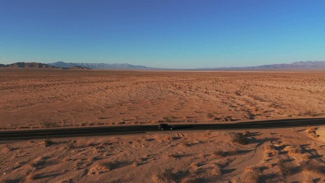Modern car driving in the desert on a road from California to Arizona. Cinematic landscape.