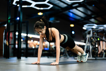 Young asian woman training exercise plank position at fitness center. Healthy and bodybuilder...