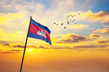 Waving flag of Cambodia against the background of a sunset or sunrise. Cambodia flag for...