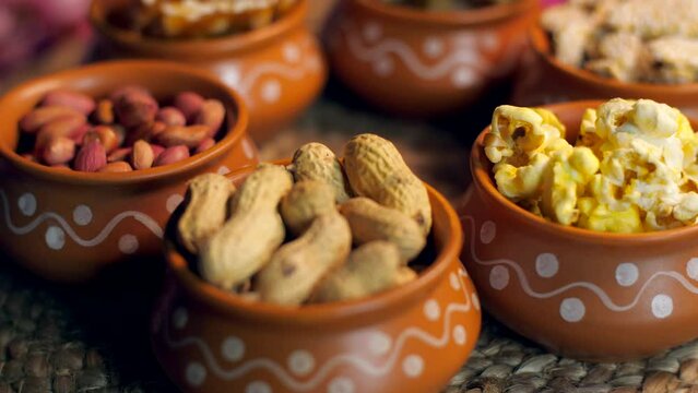 Closeup shots of peanuts  popcorn  gajak  peanuts chikki  rewri etc rotating on a turntable - Lohri festival  Makar Sankranti. Rewris  peanuts  popcorn  gajak  peanuts chikki consumed during winter...