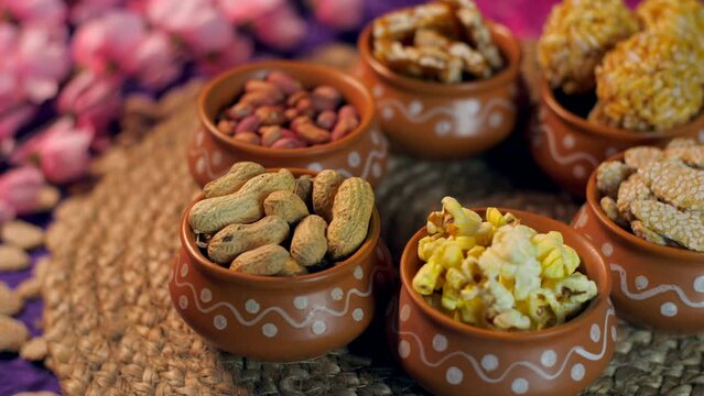 Closeup shot of homemade Indian sweet in terracotta bowls - Lohri Festival. Shot of plate full of various sweets rotating on a turntable for Lohri celebration in India