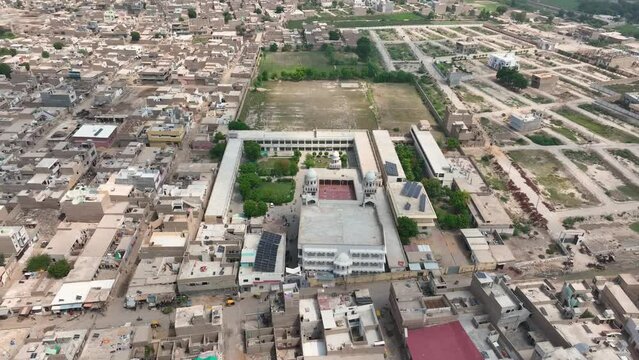 Aerial zoom out of Darul Uloom Hussainia amidst the urban grid of Shahdadpur, Sindh