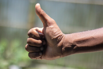 A man pointing his thumb up and blurred background