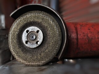 A close-up of a grinding wheel on a machine reveals sharp grit, spinning rapidly, giving off an intense metallic sound.