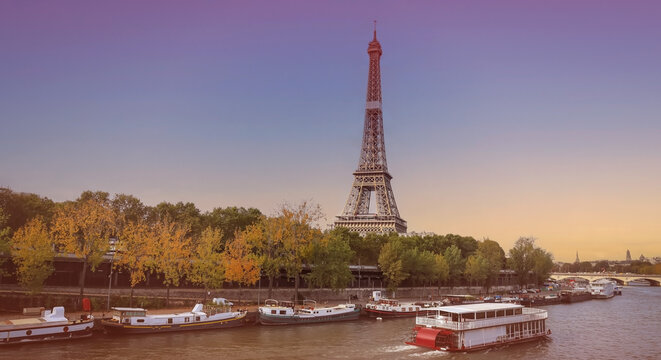 Banner of travel in Paris with Eiffel Tower iconic Paris landmark across the River Seine with  tourist boat in  Autumn tree fall scene at Paris ,France