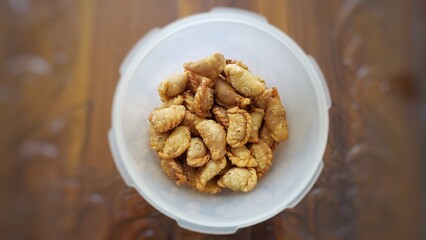 A jar of indonesian snack called pastel kering