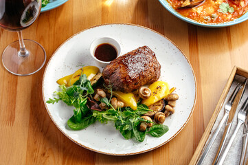 grilled beef tenderloin with vegetables and sauce on a plate