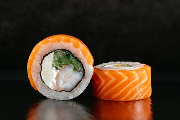 Philadelphia Japanese sushi roll with salmon on a dark backgroun
