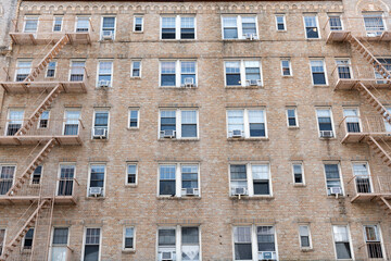 Fire escape on a building. Fire escape ladder. Detail view of an old building with a brick wall facade and an iron fire escape. Fire Escape stairs on the building wall. Residential building
