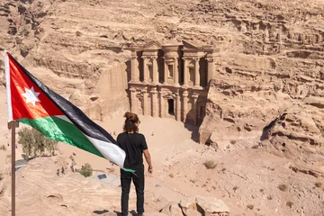Fototapeten Man and Jordanian flag with The Monastery building as background © Cavan