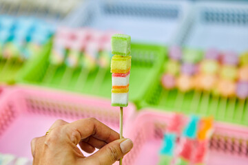 Cropped hand holding skewer jelly candies