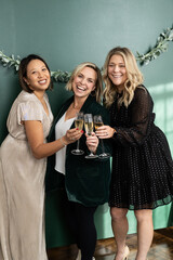 Three women dressed up holding champagne flutes