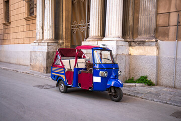 A traditional ape taxi on the streets of Palermo, Italy.