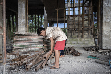 Children forced to work hard at construction site, child labor concept, poor children victims of...