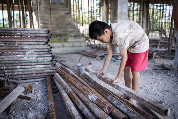 Children forced to work hard at construction site, child labor concept, poor children victims of...