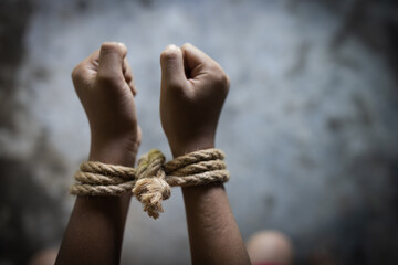 Hopeless man hands tied together with rope,  child labor concept, poor children victims of human...