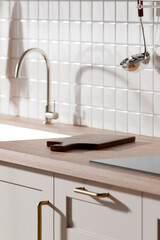 A bright beige-toned kitchen interior with sunlight 
coming through the window.
