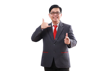 Obraz na płótnie Canvas Happy friendly asian businessman standing while making phone hand gesture and pointing at you. Isolated on white
