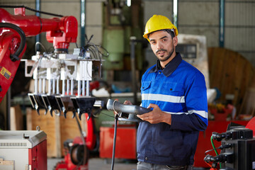 portrait factory worker or engineer operating remote switch controller to control robot machine in the factory