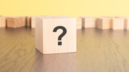 question mark written on wooden cube lying on table, business and education concept. close-up cubes