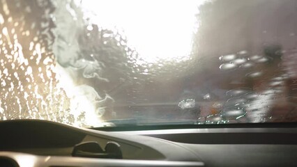 Auto detailer expertly cleanses a car with foamy cleanser and brush, restoring its brilliance. Precision and care unite in this car care masterpiece.