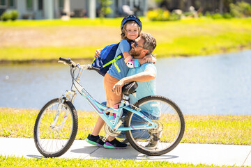 happy son and daddy cycling on bicycle. daddy teaching his son child to ride a bicycle. daddy and son kid outdoor. Fostering a sense of togetherness. daddy and son spend time together