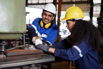 male worker or engineer have been injured in an accident from working on machine and coworker try...
