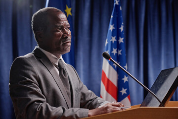 African American politics in suit speaking his speech in microphone during conference