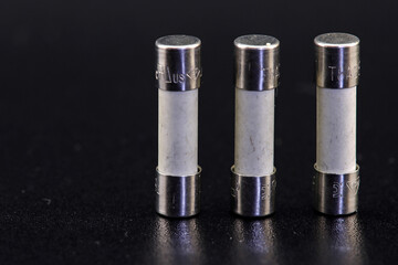 Electric fuses to protect electrical circuits. On a dark background, close-up.