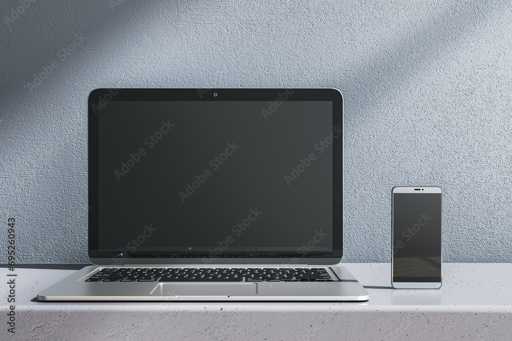 Poster close up of empty laptop and smartphone on gray desk. concrete wall background. device presentation 