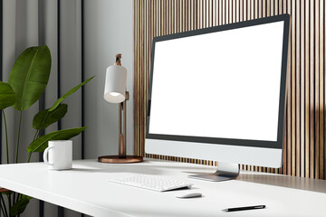 Close up and side view of modern workplace with empty white computer monitor, coffee cup, supplies, plant, lamp and other items on wooden wall background. Mock up, 3D Rendering.
