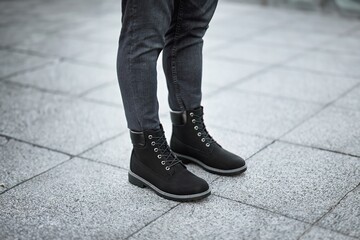 A pair of stylish dark brown leather boots paired with grey denim jeans captures the essence of modern urban fashion.