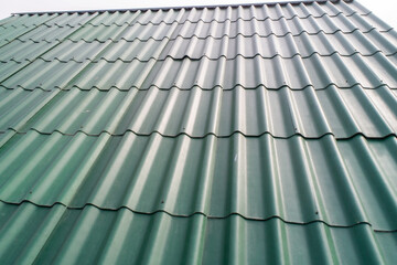 Modern roof. Roofing covering. Roman profile. The roof of the house is covered with wavy green tiles.