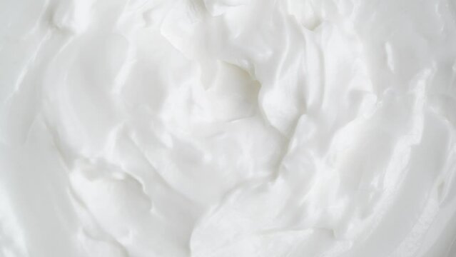 White smooth creamy moisturizing face cream texture, rotation, macro. Top view