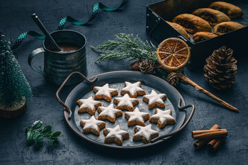 Christmas gingerbread cookies stars with icing on seasonal holiday background with old rustic cup,...