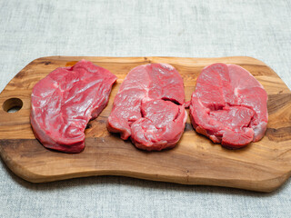 Fresh juicy boneless lamb steak on a wooden board. Premium meat product for cooking. High quality meat cut. Food chain.