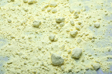 Powdered sulphur, a chemical element. Yellow background.