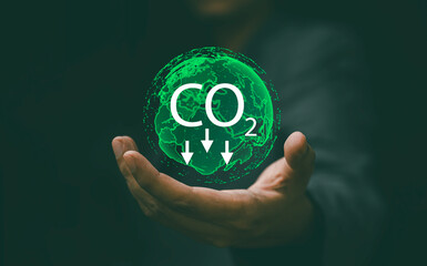 carbon emission concept, businessman hand holding virtual global, carbone footprint and carbon credit for green business.reduction co2. - obrazy, fototapety, plakaty