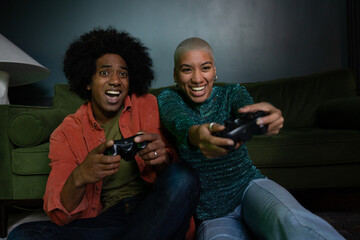 Couple playing a video game at home at night