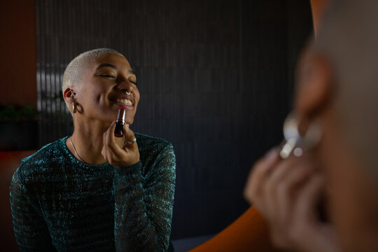 Woman doing makeup in a bathroom mirror to go out
