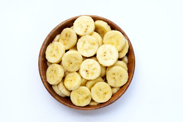 Banana slices in wooden bowl on white background.