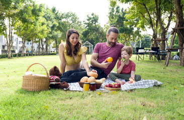 Joyful family enjoying outdoor picnic in sunny park