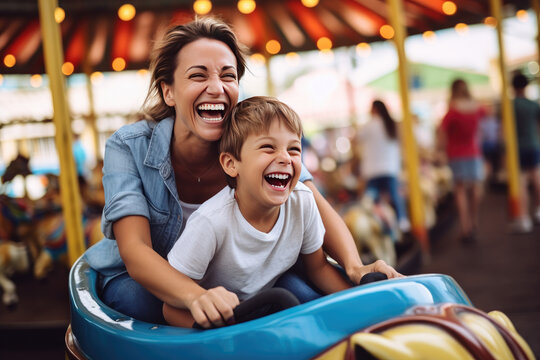 Joyful mother and son enjoying a fun summer, riding a bumper car at an amusement park